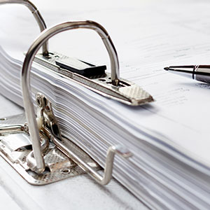 binder with documents and a pen on a table organizing paperwork for two tasks