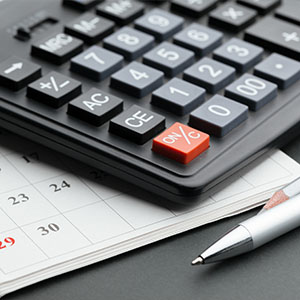 calculator on a calendar with a pen showing date 12 financial planning and budgeting