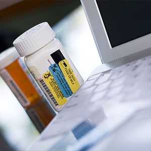 two prescription medication bottles on a table next to a laptop keyboard including a label that indicates dosage instructions to remember medications for daily health management 9 tips for safety